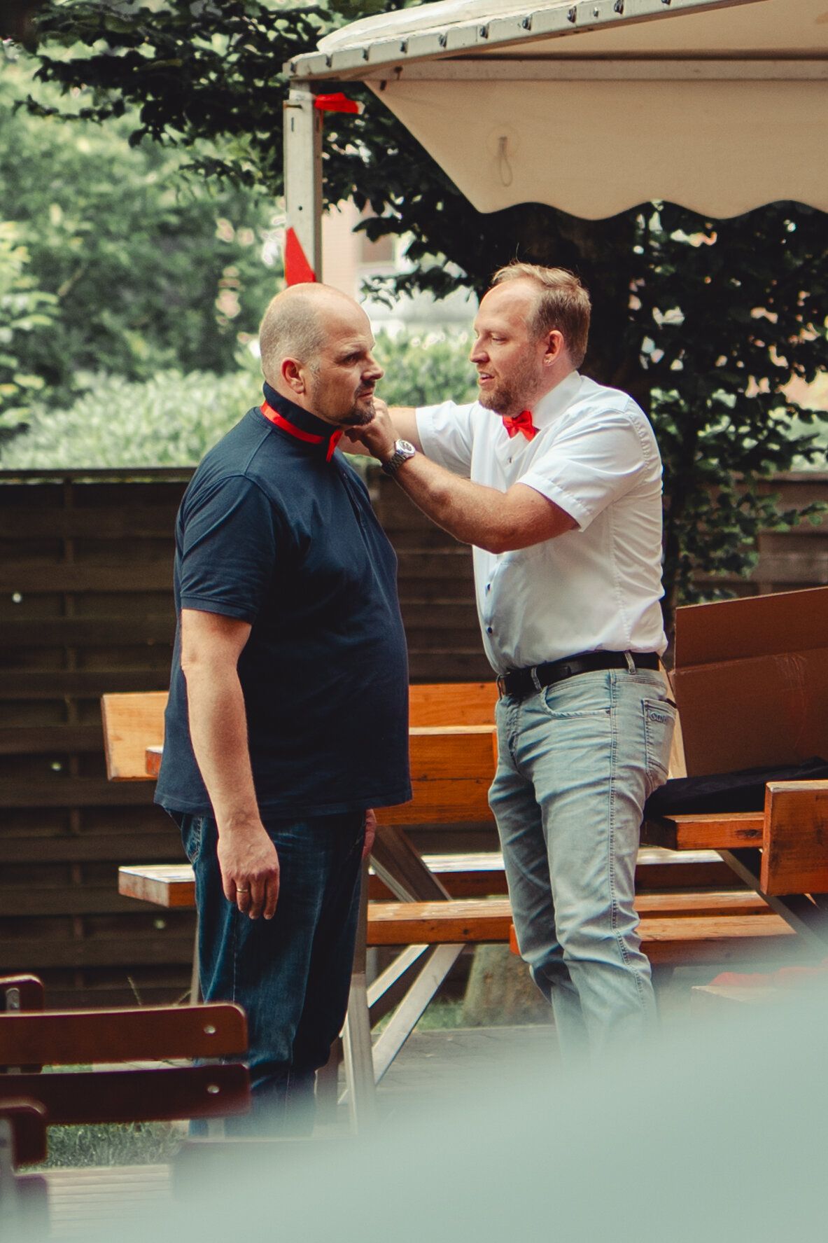Kai Hemmieoltmanns mit roter Fliege rückt einem Genossen das rote Halstuch zurecht, beim Sommerfest
